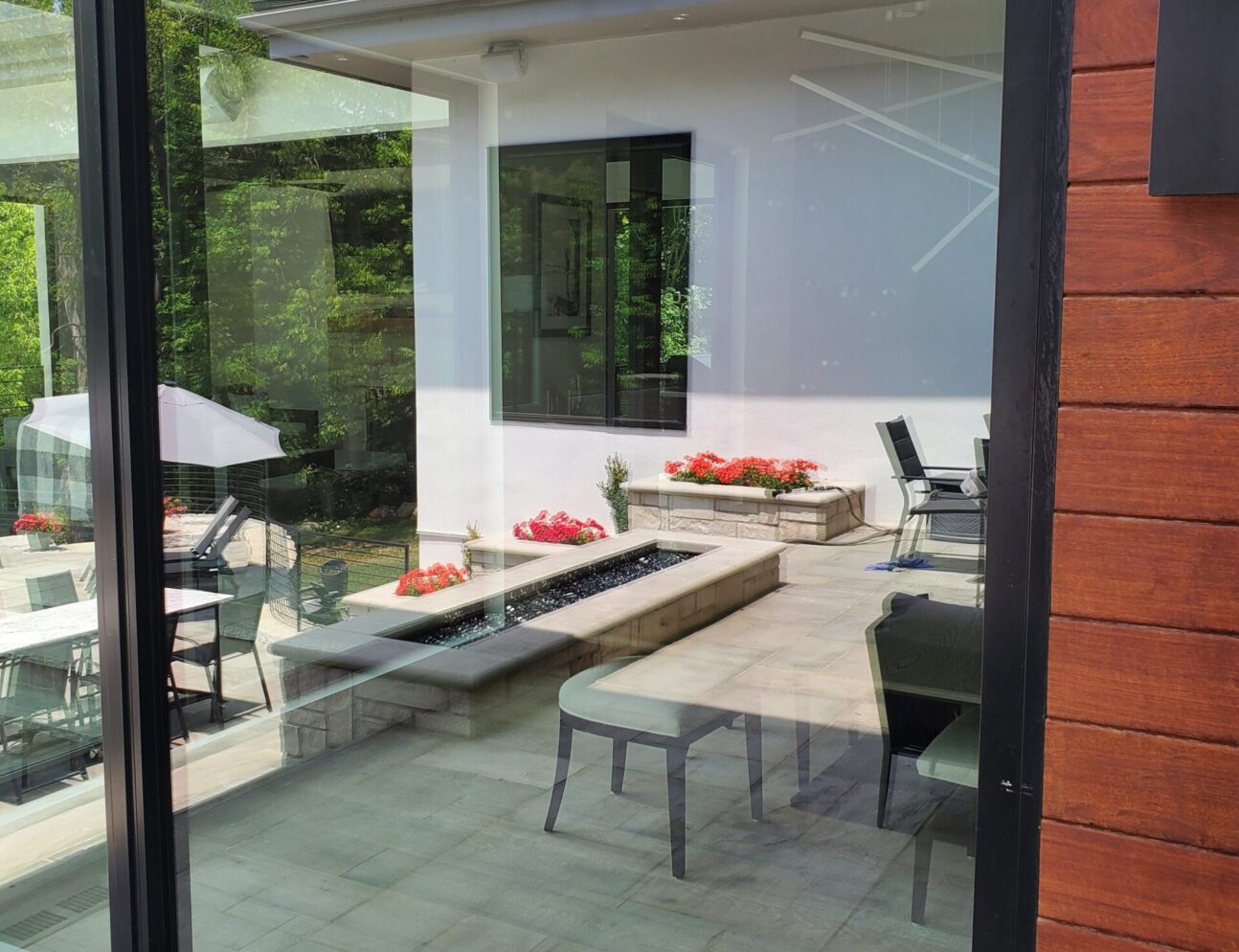 a large residential window with a reflection of an outdoor deck