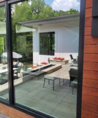 a large residential window with a reflection of an outdoor deck