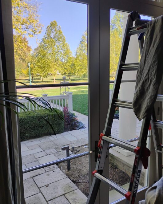 a frame ladder inside a living room in front of a residential window