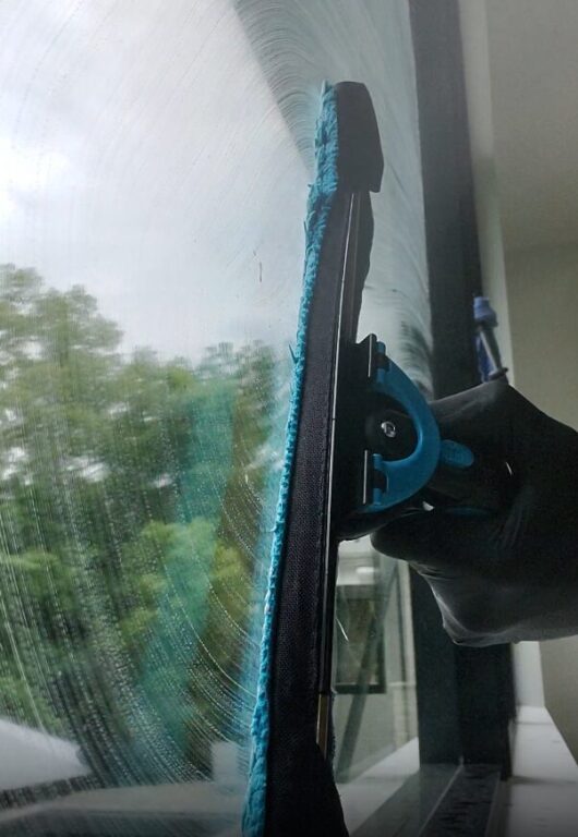 large residential window getting cleaned with a squeegee