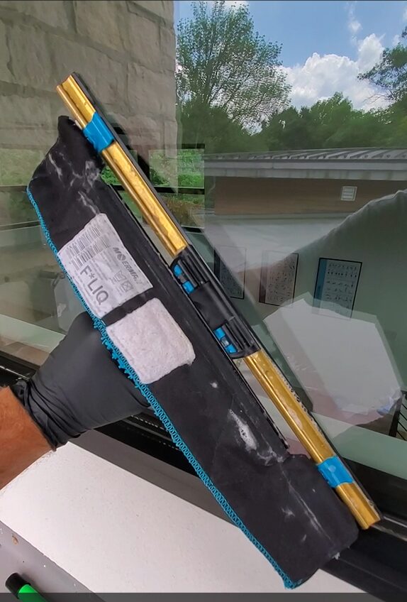 a squeegee getting pulled across a residential window